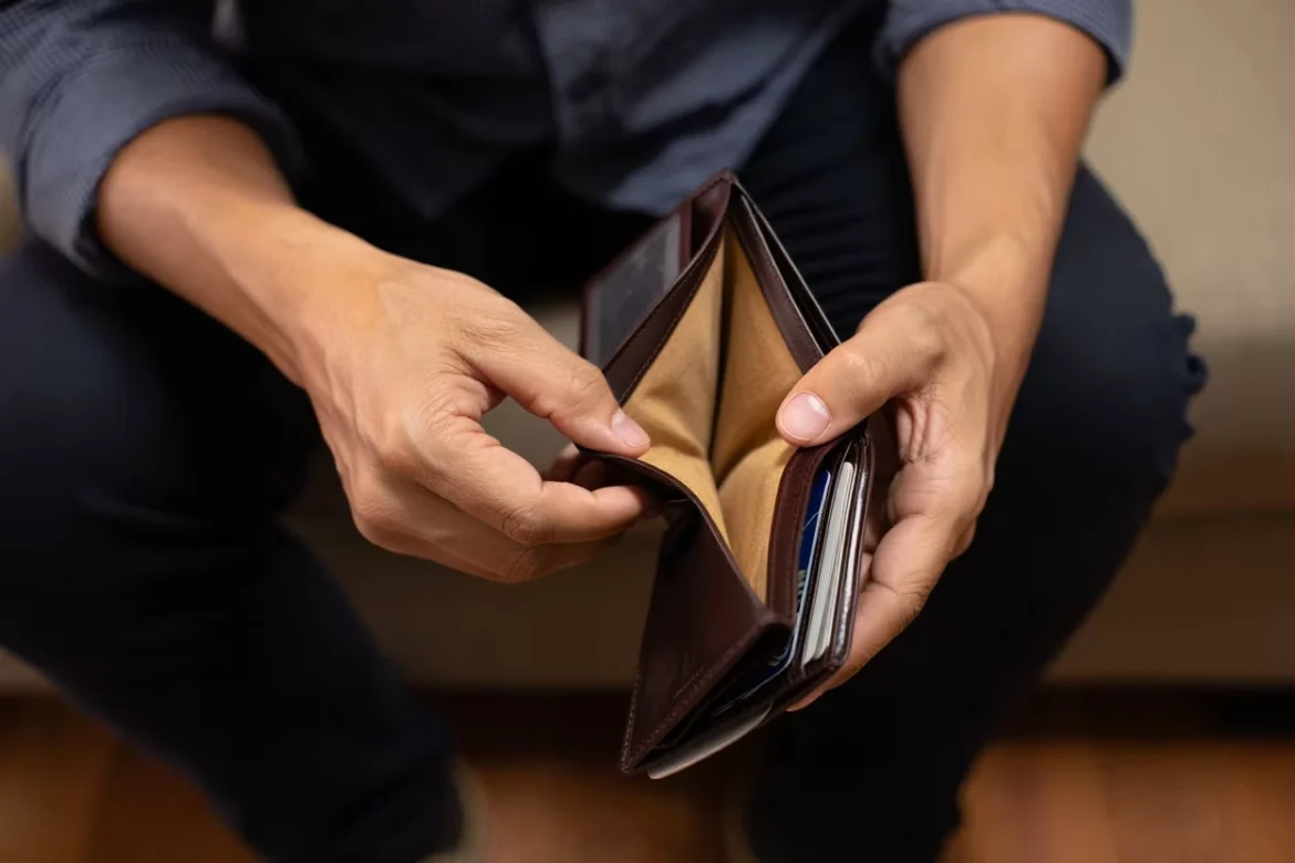 pessoa anotando finanças no caderno e olhando app de finanças no celular, simbolizando simplicidade